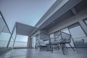 2 sedie e un tavolo sul balcone con finestre di Eden Kolwezi a Kolwezi