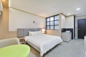 a bedroom with a large white bed and a table at No25 Samcheonpo in Sacheon +31 photos