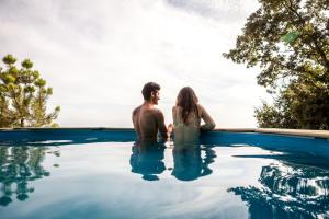 a man and a woman sitting in a swimming pool at Traços D'Outrora in Vale de Cambra