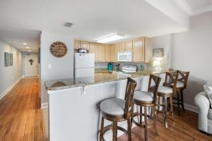 a kitchen with a bar with stools at Harbour Pointe 605 By Pkrm in Perdido Key