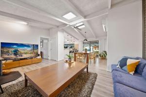 a living room with a blue couch and a table at Ashwood Alpine House in Bright