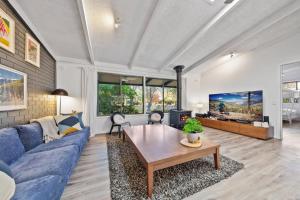 a living room with a blue couch and a table at Ashwood Alpine House in Bright