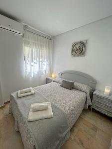 una camera da letto con due letti con asciugamani sopra di Apto Córdoba FAMORCAS ad Almodóvar del Río
