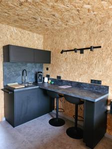 a kitchen with a black counter and a sink at La Studette in Bénouville