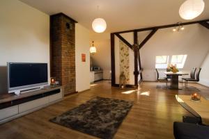 a living room with a flat screen tv and a table at Apartament Serce Ustronia in Ustroń