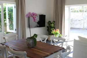 a dining room with a table with a flower on it at Jakaranda Cottage in Somerset West