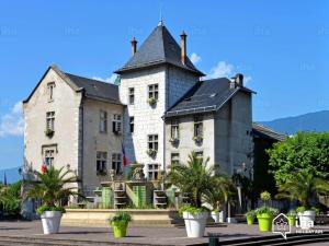 a large building with palm trees in front of it at Joli studio au centre ville in Aix-les-Bains