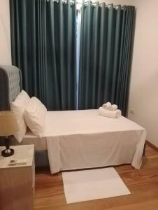 een kleine kamer met een bed en een gordijn bij 2BR Apartment in Capitol Twin Peaks 24th Floor in Colombo