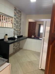 Il comprend une cuisine équipée d'un comptoir noir et d'un réfrigérateur. dans l'établissement Casa de férias luar do prado, à Prado