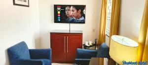 a living room with two blue chairs and a tv at ShaMooL Hotel in Dar es Salaam