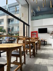 a restaurant with wooden tables and chairs and a flat screen tv at Cozy Abode by Embassy Gardens in Cantonments