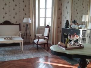 ein Wohnzimmer mit einem Sofa und einem Tisch in der Unterkunft Château de Prety - Maison d'Hôtes in Préty