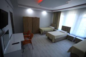 a hotel room with two beds and a table and chairs at Hotel Cappa in Ürgüp