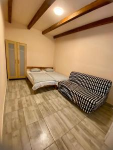 a room with two beds and a couch in it at Tieffapartmanház Zamardi in Zamárdi
