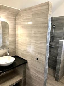 a bathroom with a sink and a shower at Tieffapartmanház Zamardi in Zamárdi +38 photos