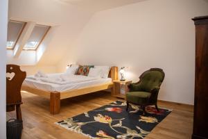 a bedroom with a bed and a chair at Tokaji Dűlő Vendégház in Tokaj