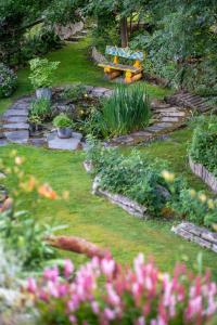 a garden with a bench and some plants and flowers at Studio Cinq Moutons in Orsières +2 photos