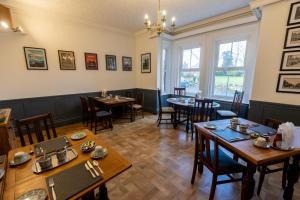 a restaurant with tables and chairs in a room at The Cedars Ashby in Ashby de la Zouch