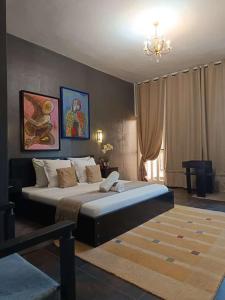 OuidahRESIDENCE MGA HOTEL的一间带大床和吊灯的卧室