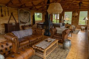a living room with leather furniture and a fireplace at Estancia Bonanza Patagonian Lodge Experience in El Chalten