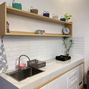 日惹Sampai Villa Tugu的厨房柜台设有水槽和书架