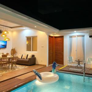 日惹Sampai Villa Tugu的一间带游泳池的客厅和一间客厅