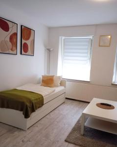 a white bedroom with a bed and a window at Wohnen im Zentrum von Krefeld in Hubi1 in Krefeld