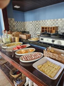 a buffet with many plates of food on a table at Malie Hotel in Águas Belas