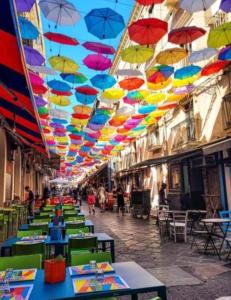 カターニアにあるAlle Porte Del Pigno Houseの天井から傘がぶら下がっているテーブルの列