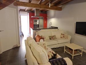 ein Wohnzimmer mit zwei weißen Sofas und eine Küche in der Unterkunft Casa Misi in Candeleda