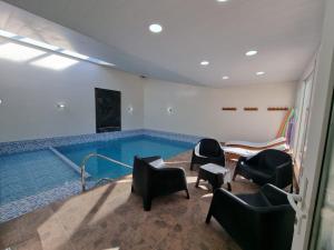 une piscine avec des chaises noires et des chaises dans une pièce dans l'établissement Susy Rental Depto N 3, à Malargüe