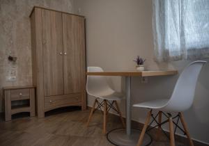 a room with a table and two chairs and a cabinet at Къща за гости Фолис in Kyustendil