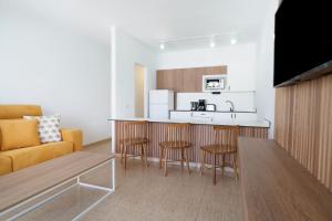 Una sala de estar con un sofá y una cocina. en Labranda Playa Club, en Puerto del Carmen