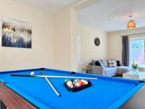Una sala de estar con una mesa de billar con dos tacos. en Spacious 6 Bedroom Home with Pool Table - Free Driveway Parking - 12 beds and 3 Bathrooms - Rustic Cottage Features, en Teversall