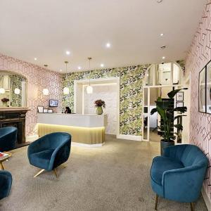 a lobby with blue chairs and a reception desk at George Hotel in London
