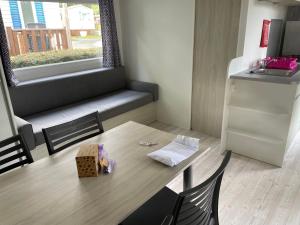 une petite cuisine avec une table et un réfrigérateur dans l'établissement Mobilhome 29, à Bérigny