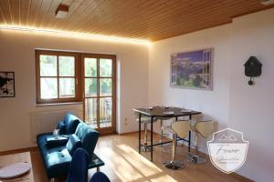 a living room with a table and a blue couch at Ferienwohnungen Schönwetter Oberpfaffenhofen in Weßling +12 photos