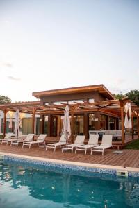 a pool with white lounge chairs and a house at Aurorae Residence in Recaş +22 photos