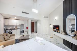 a large living room with a couch and a kitchen at Comfortable Studio with Dubailand Vibes in Dubai