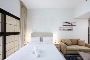 a white bedroom with a bed and a couch at Comfortable Studio with Dubailand Vibes in Dubai +31 photos