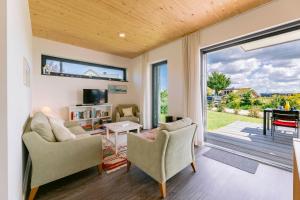 ホーヴァハトにあるHaus Strandlustのリビングルーム(椅子2脚、ガラスのスライドドア付)