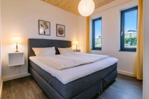 ホーヴァハトにあるHaus Strandlustのベッドルーム1室(大型ベッド1台、窓2つ付)