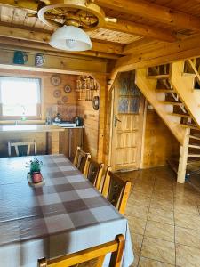 a dining room with a table and a kitchen at Dom letniskowy ANTOLEK in Ryn