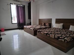 a bedroom with two beds and a window at Ashirwad Hotel in Rīngas