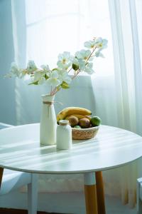 迪拜The Villa Jumeirah的一张桌子,上面放着一碗水果和花瓶