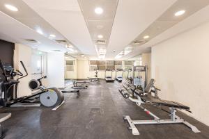 a gym with a bunch of treadms and machines at Comfortable Studio with Dubailand Vibes in Dubai