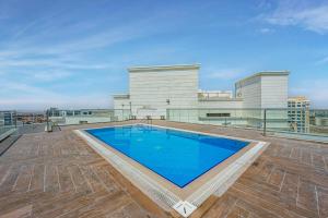 a swimming pool on the roof of a building at Comfortable Studio with Dubailand Vibes in Dubai