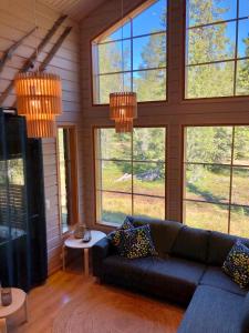 a living room with a couch and large windows at Petäjähovi in Kuusamo