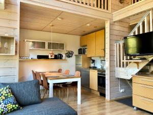 a kitchen and dining room with a table in a tiny house at Petäjähovi in Kuusamo