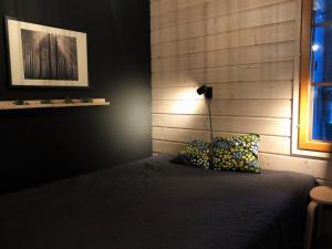a bedroom with a bed with a lamp and two pillows at Petäjähovi in Kuusamo +19 photos